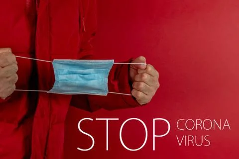 Man in red jacket is using a protective mask against corona virus on red back Stock Photos