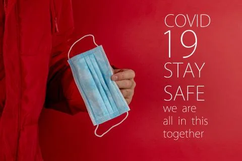 Man in red jacket is using a protective mask against corona virus on red back Stock Photos