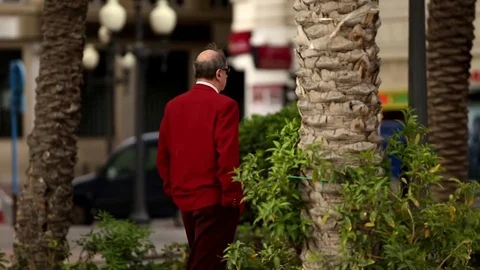 A man in a red jacket walking down the street Stock-Footage 75217007