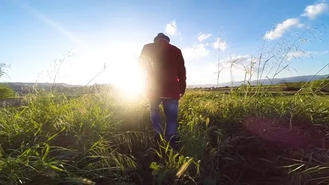 Man with red jacket walks in slow motion , backlight Stock Footage 92499493