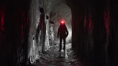 A man with a red lantern walks in an wet underground arch sewer collector. Stock Footage 197122460