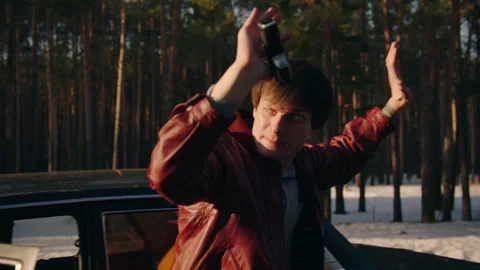 Man in red leather jacket putting his hands up while holding a gun Stock Footage 283107734