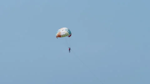 Man with a red life jacket parasailing in Pattaya with a fantastic blue Stock Footage 257550081