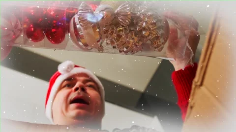 Man in red receiving parcel, takes out a set of Christmas tree balls 스톡 동영상 255459108