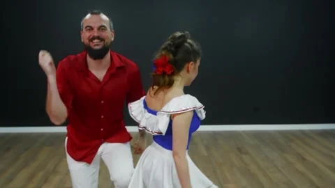 Man in red shirt dancing bachata with woman in white dress 스톡 동영상 337216701