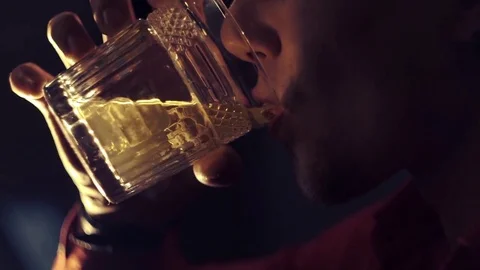 Man in a red shirt is drinking whiskey at the bar Stock Footage 83705273