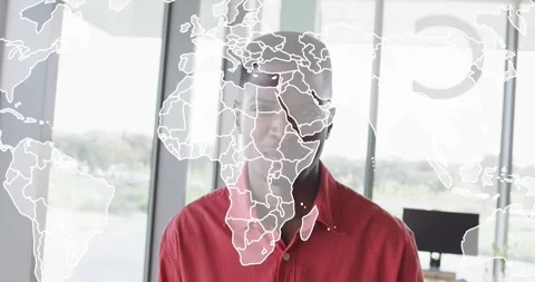 Man in red shirt standing by window while world map fading across face Stock Footage 328524437