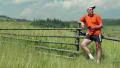 Man with red smartphone stands in the field and listens to music HD Footage