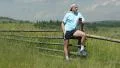 Man with red smartphone stands in the field and listens to music HD Footage