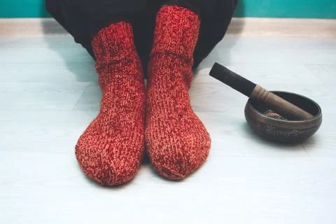 Man in a red woolen socks sitting on the floor in the yoga studio with a si.. Stock Photos