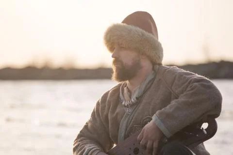 Man reenactor playing gusli Stock-Fotos