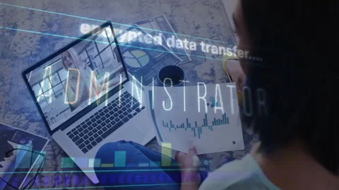 Man referencing charts glancing laptop as business call starting with encrypted Stock Footage 310430736