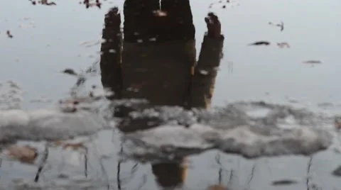Man Reflected in a Half-Frozen Puddle Stock Footage 47855558