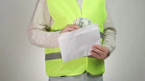 A man in a reflective construction cape takes money out of an envelope. An 스톡 동영상 314033807
