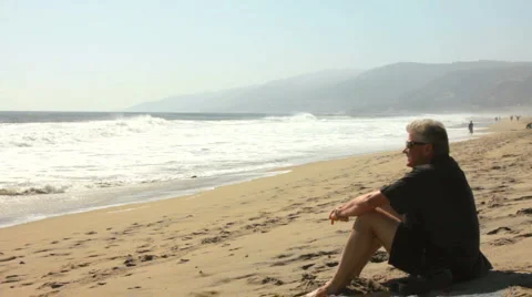 MAN REFLECTS AT BEACH 2 Stock Footage 5645728
