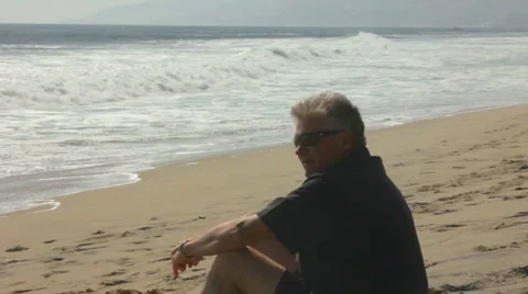 MAN REFLECTS AT BEACH Stock Footage 5638765
