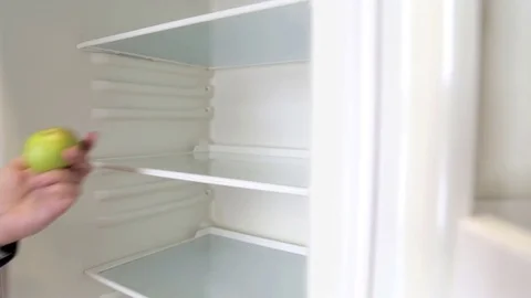 The man in the refrigerator takes an apple Stock Footage 72401852