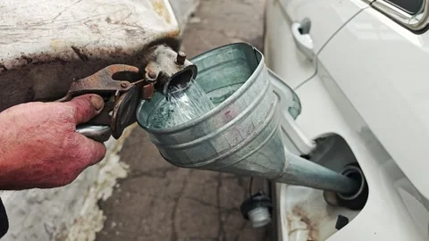 Man refueling car with gasoline using a portable metal canister Video stock 340103079