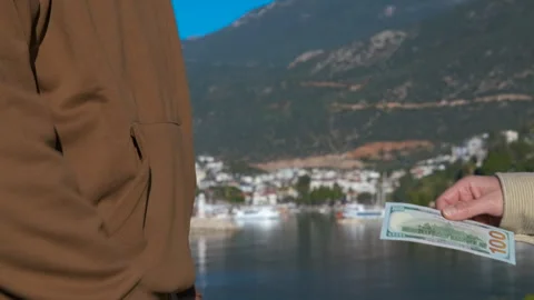 Man refusing and accepting money on a seaside background Stock Footage 306693820