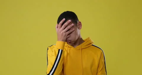 Man regretting his wrongdoing over yellow background Stock Footage 146051012