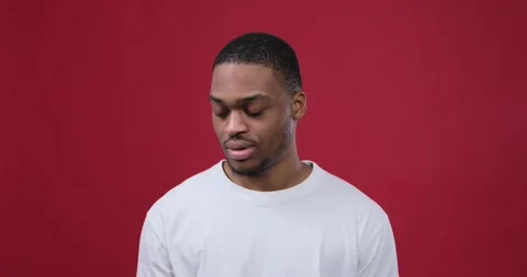 Man regretting wrongdoing over maroon background Stock Footage 147620431