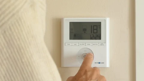 Man regulating adjusting smart Thermostat room temperature at home Stock Footage 102620385