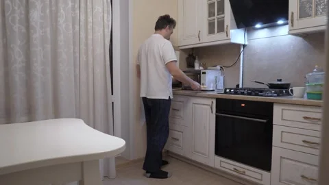 A man reheats dinner at home Vidéo 336513632