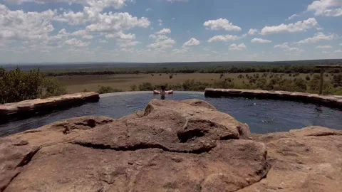 A man relaxes at the edge of an infinity pool. Stock Footage 135438607