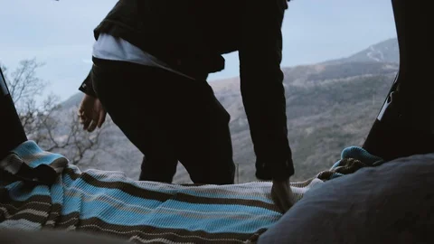 Man relaxes inside trunk and watches at the autumn mountains Stock Footage 102821204