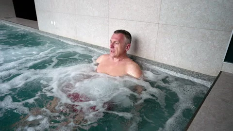 A man relaxes in a jacuzzi pool. Stock Footage 311245573