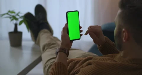 Man is relaxing in apartment, using mobile phone, surfing internet and shopping Stock Footage 146883390