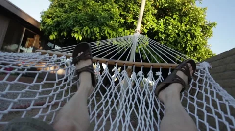 Man relaxing in a backyard hammock Stock Footage 58608165