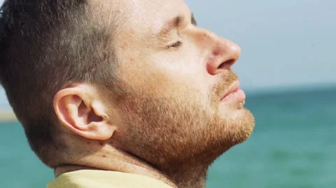 Man relaxing on the beach and having his eyes closed, steadycam shot Stock-Footage 63206247