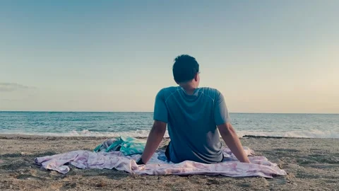 Man relaxing on the beach while gazing at the Mediterranean Sea horizon Video stock 346678012
