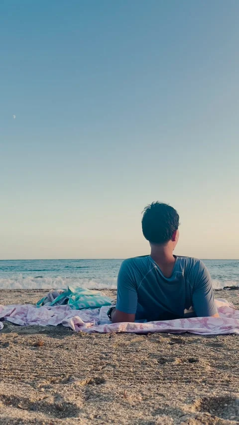 Man relaxing on the beach while gazing at the Mediterranean Sea horizon Stock Footage 346678015