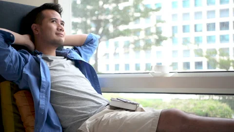 The man relaxing on couch and drinking coffee in a room Stock Footage 132882885