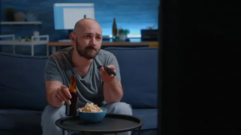 Man relaxing on cozy couch using remote controller switching tv channels Vídeo Stock 153584176
