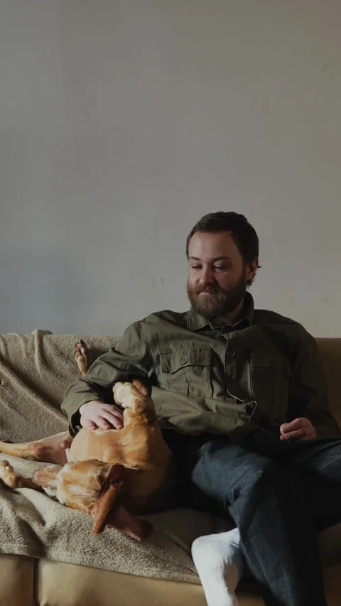 Man Relaxing With Dog at Home 動画素材 320803624