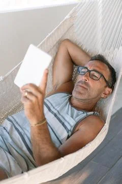 Man Relaxing with E-Book in hammock Stock Photos