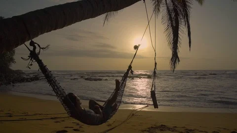 Man Relaxing In Hammock On The Beach Stock Footage 98058372