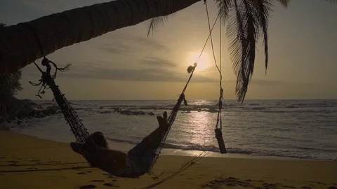 Man Relaxing In Hammock On The Beach Stock Footage 98058377