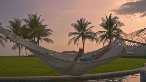 Man relaxing on a hammock during sunset Stock Footage 183540861