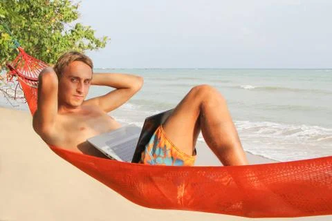 Man Relaxing In Hammock With E-Book 写真素材