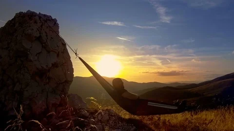 Man relaxing in hammock at sunset in the mountains Stock-Footage 80114941