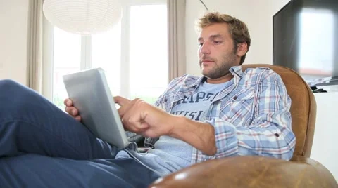 Man relaxing at home and using digital tablet Stock Footage 52026965