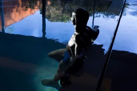 Man relaxing in indoor pool Stock Photos