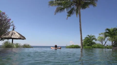 Man relaxing in infinity pool Video stock 65826702