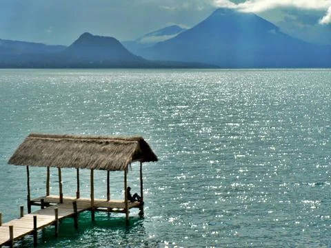 Man relaxing on lake Atitlan, Guatemala with volcano in background Stock Photos
