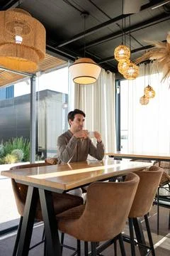 Man relaxing in modern cafe drinking coffee Stock Photos