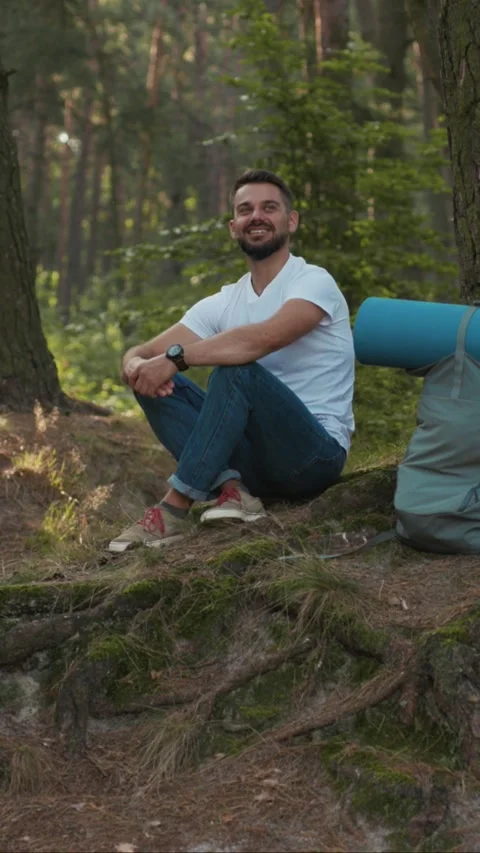 A Man is Relaxing in Nature While Camping, Enjoying the Ambience and Stock Footage 314168092